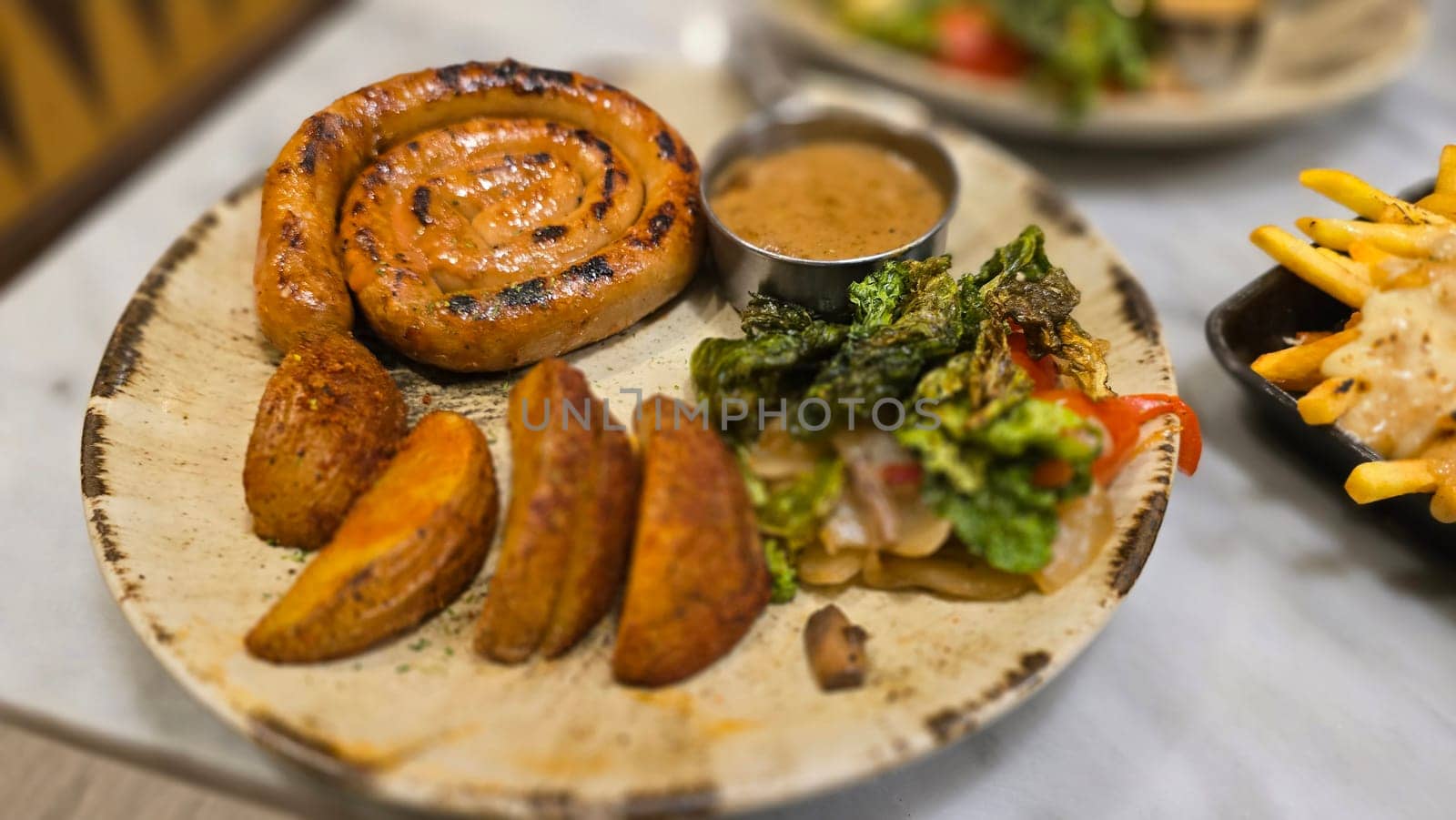 mouthwatering German worst curled up cumberland sausage meal featuring a grilled sausage, loaded cheese fries, and fresh vegetables served on a rustic plate. Perfect for dinner lovers appreciating hearty and flavorful dishes.