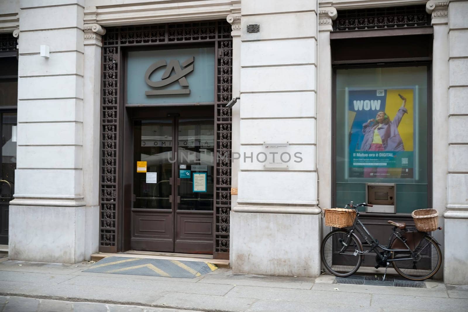 Cremona, Italy - November 20th 2024 Elegant facade of banco bpm palace in cremona. Italy. Featuring a parked bicycle and a vibrant advertising poster