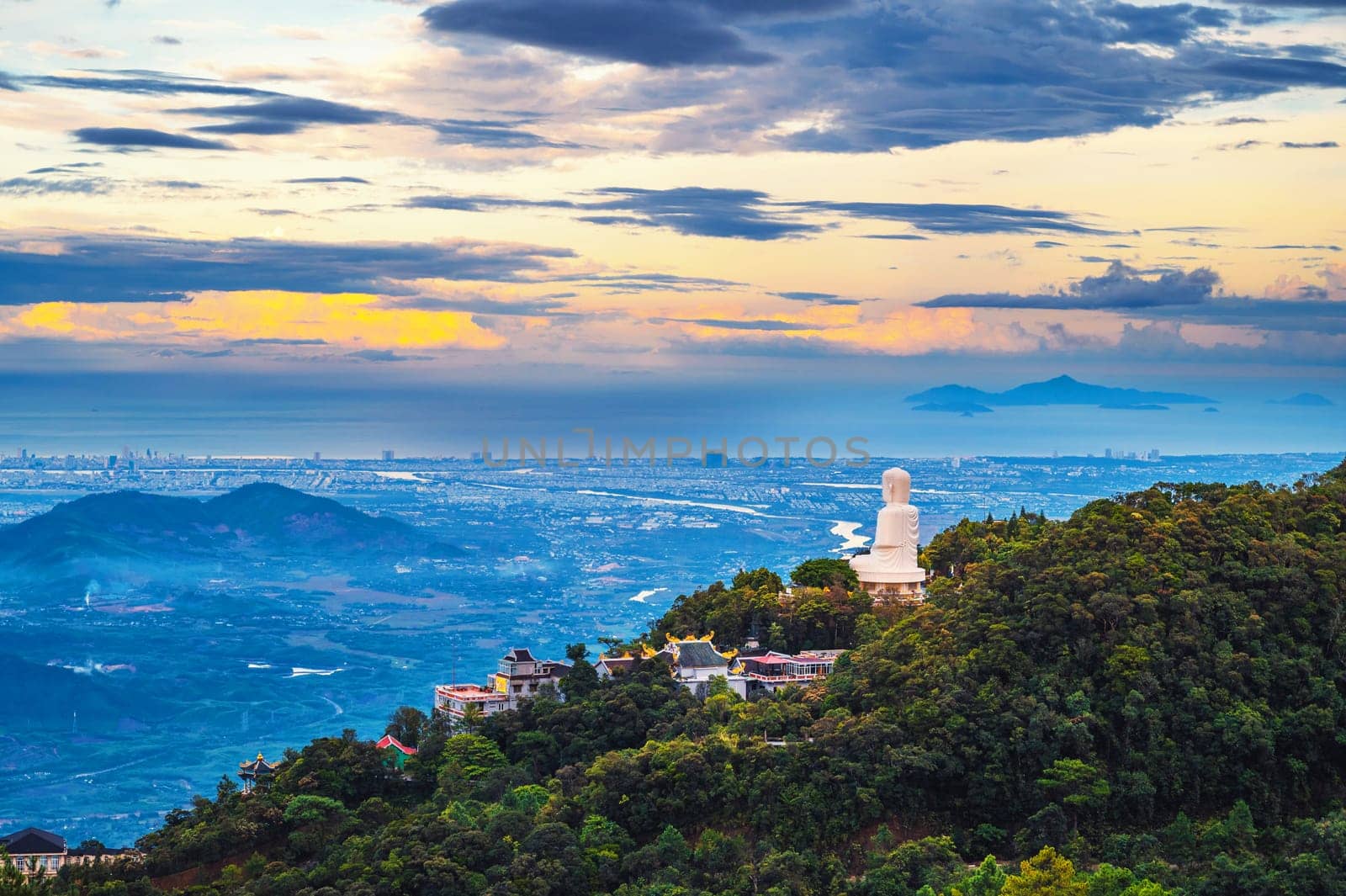 Top view of Da Nang city and Buddha statue from a mountain in the Ba Na Hills in Vietnam at sunset