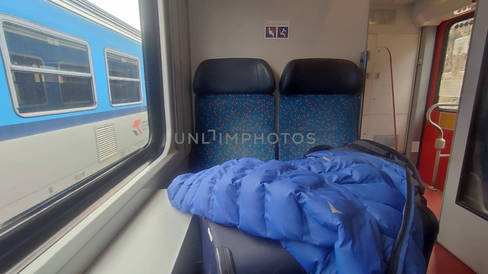 October 21 2024 Stara Paka, Czech Republic, street, railway station, building, transport, train blue carriage, window luggage seats, jacket movement, sign. High quality photo