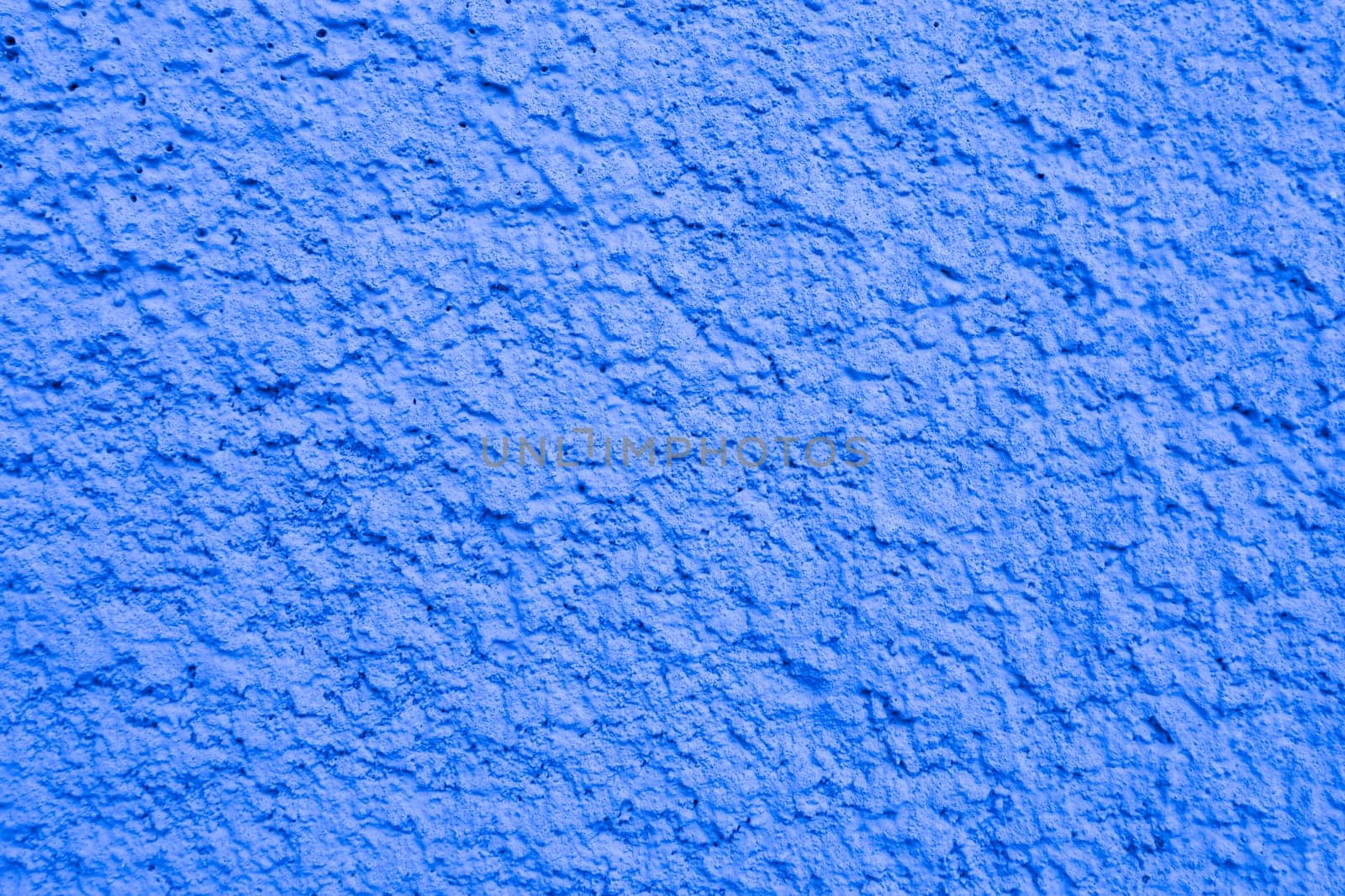 Abstract background of light blue shabby plaster close-up.