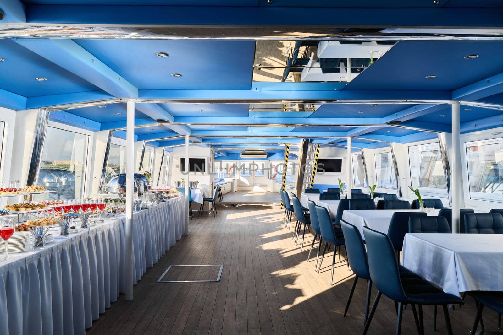 The boats elegant interior with tables and a stunning view is perfect for dining or hosting events