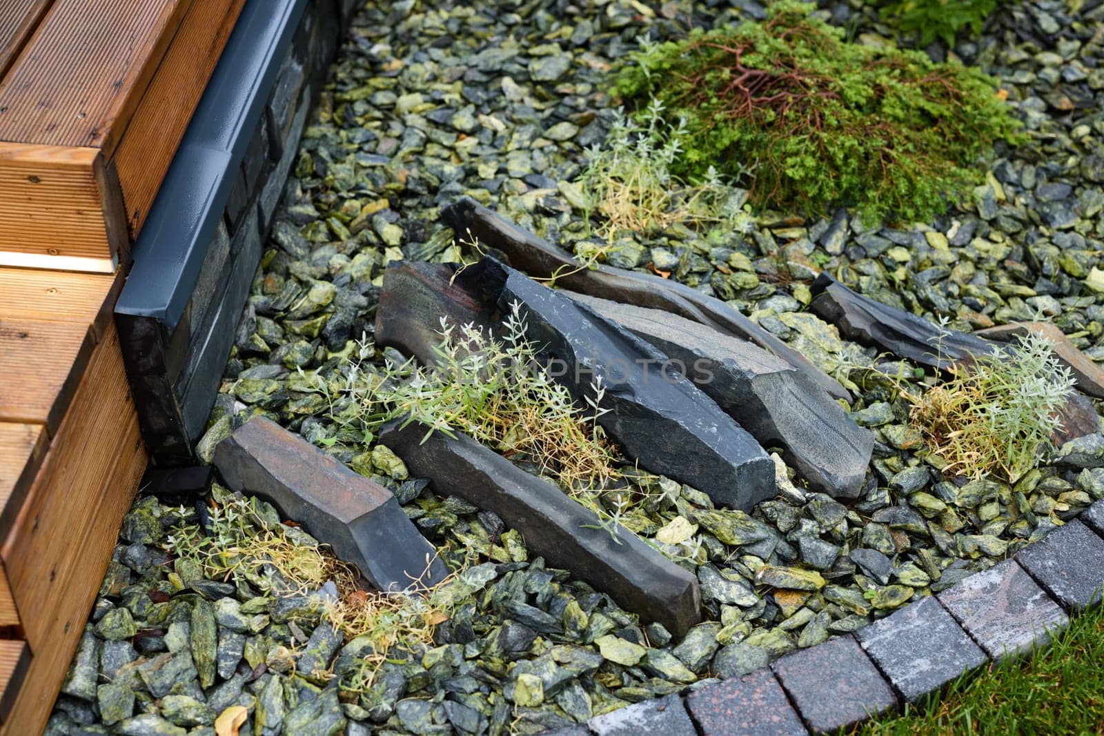 A serene garden scene with natural stones, gravel, and lush greenery enhances the landscape aesthetics beautifully