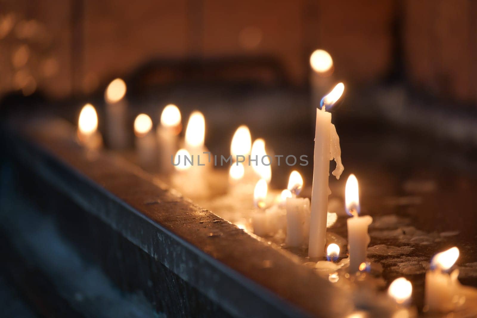 Row of burning candles in a church