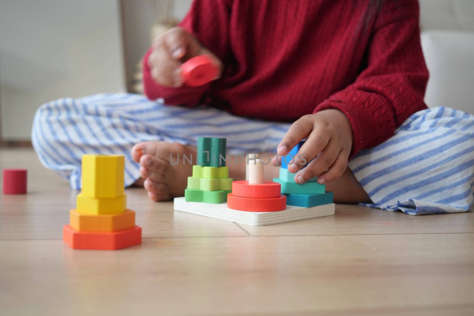 A child joyfully plays with colorful stacking toys that improve motor skills and coordination