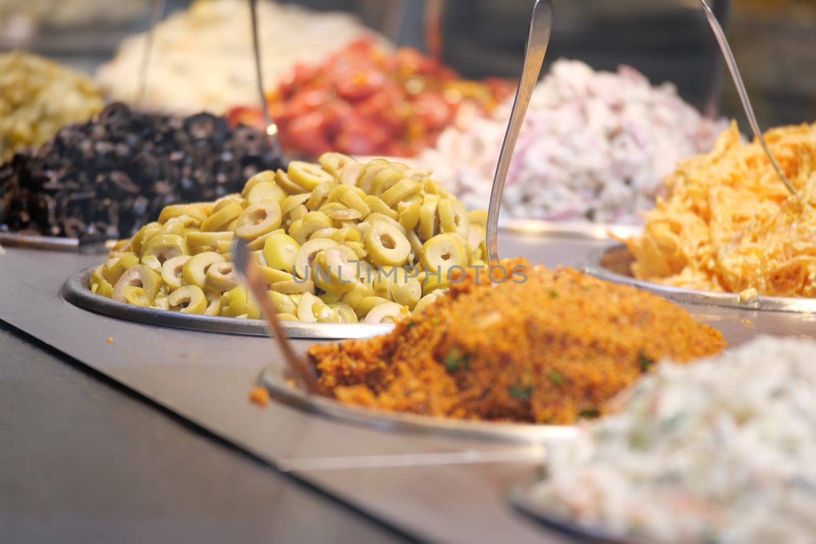 A colorful assortment of olives, fresh salads, and aromatic spices on display for all