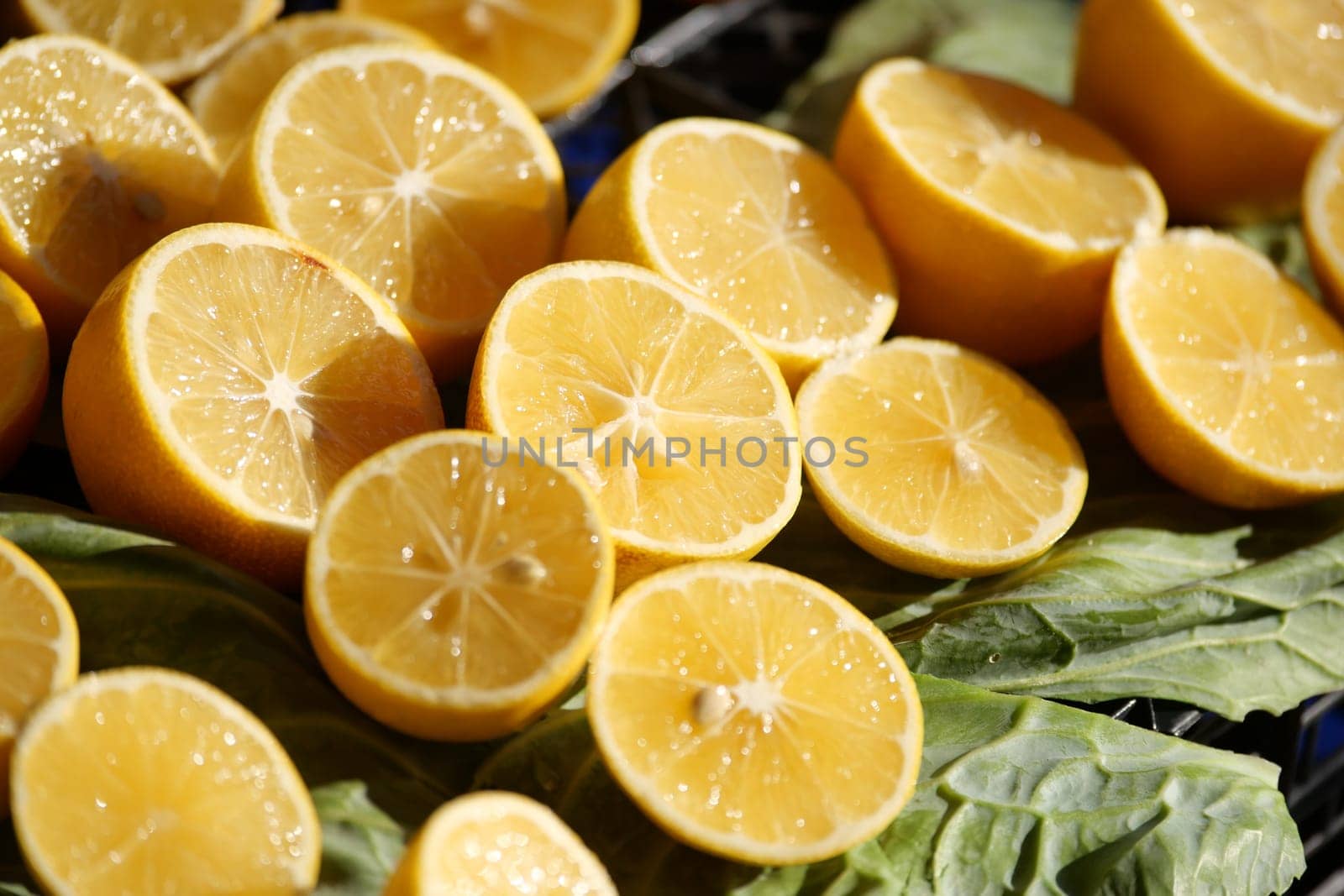 Bright lemon halves arranged on fresh green leaves, ideal for various dishes and drinks