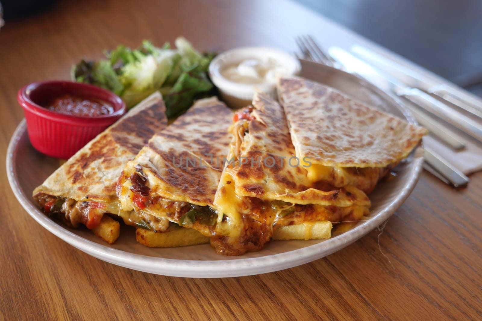Enjoy the rich flavors of a quesadilla platter served with fresh salsa and greens