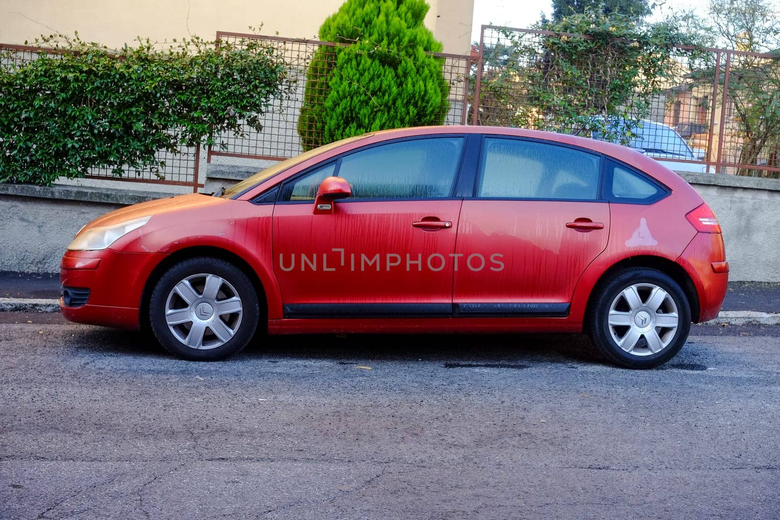 Cremona, Itally - October 6th 2024 Red citroën c4 1.6 hdi parked on the side of a residential street, showing its side view