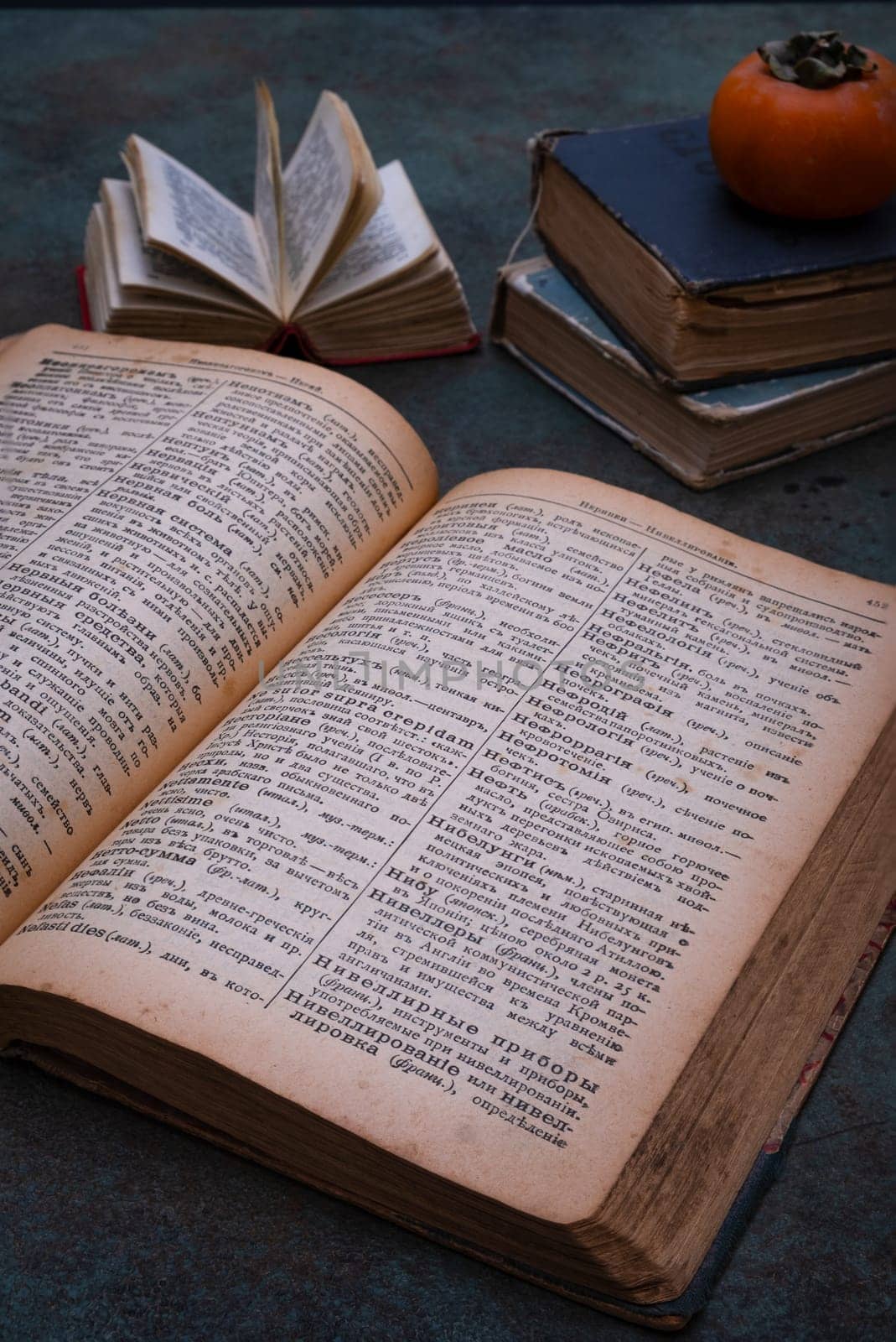 Close-up of several old dictionaries against a dark background. Selective focus.