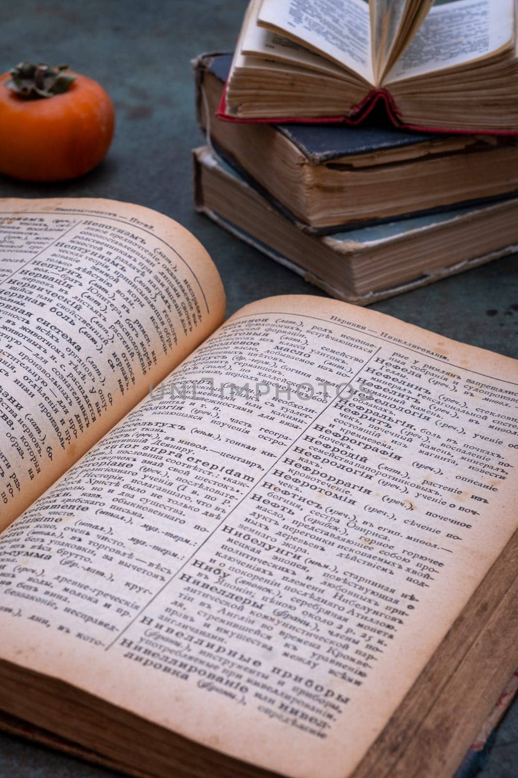Close-up of several old dictionaries against a dark background. Selective focus.