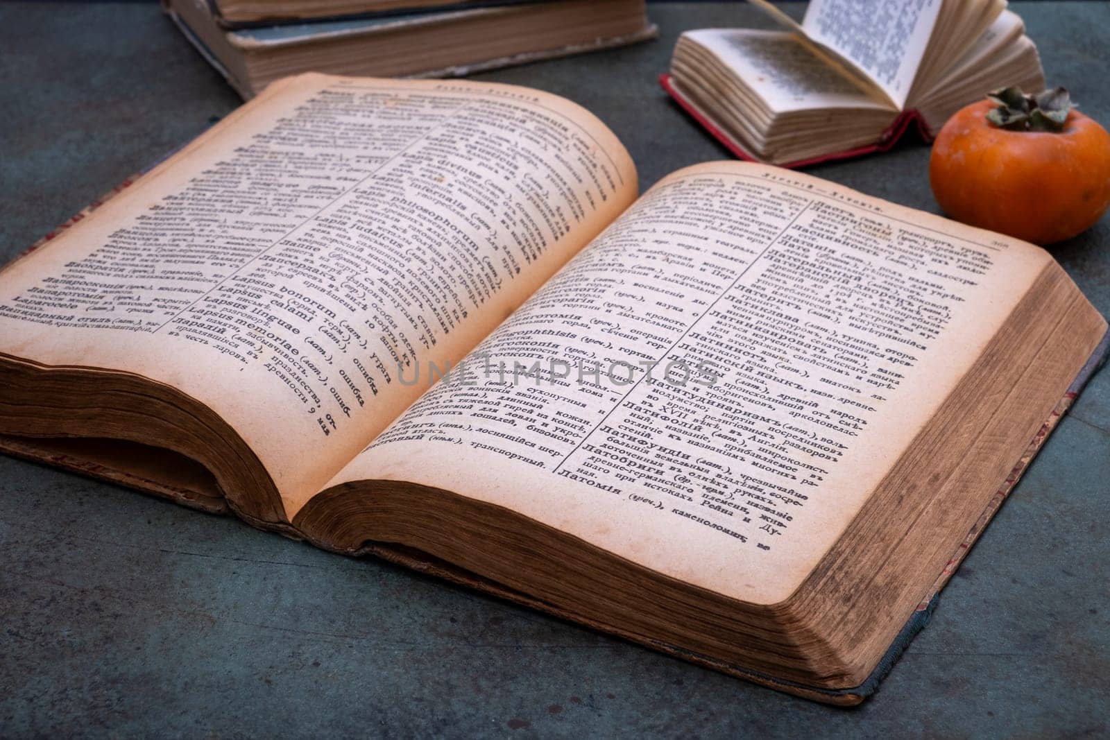 Close-up of several old dictionaries against a dark background. Selective focus.