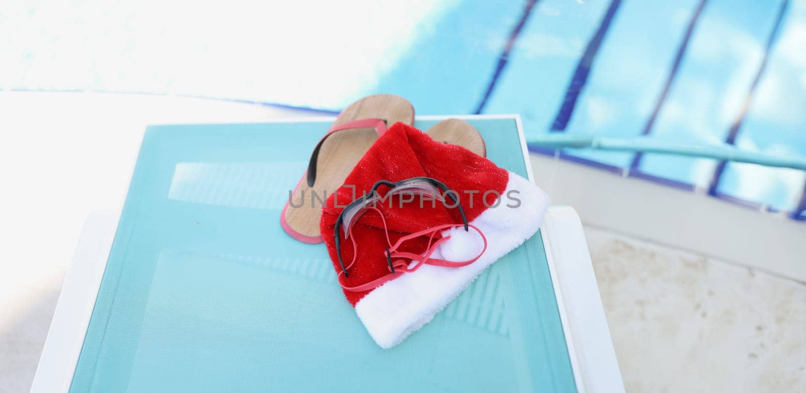 Santa Claus hat and accessories for swimming in the pool, close-up. New Year in warm countries, winter recreation on the water