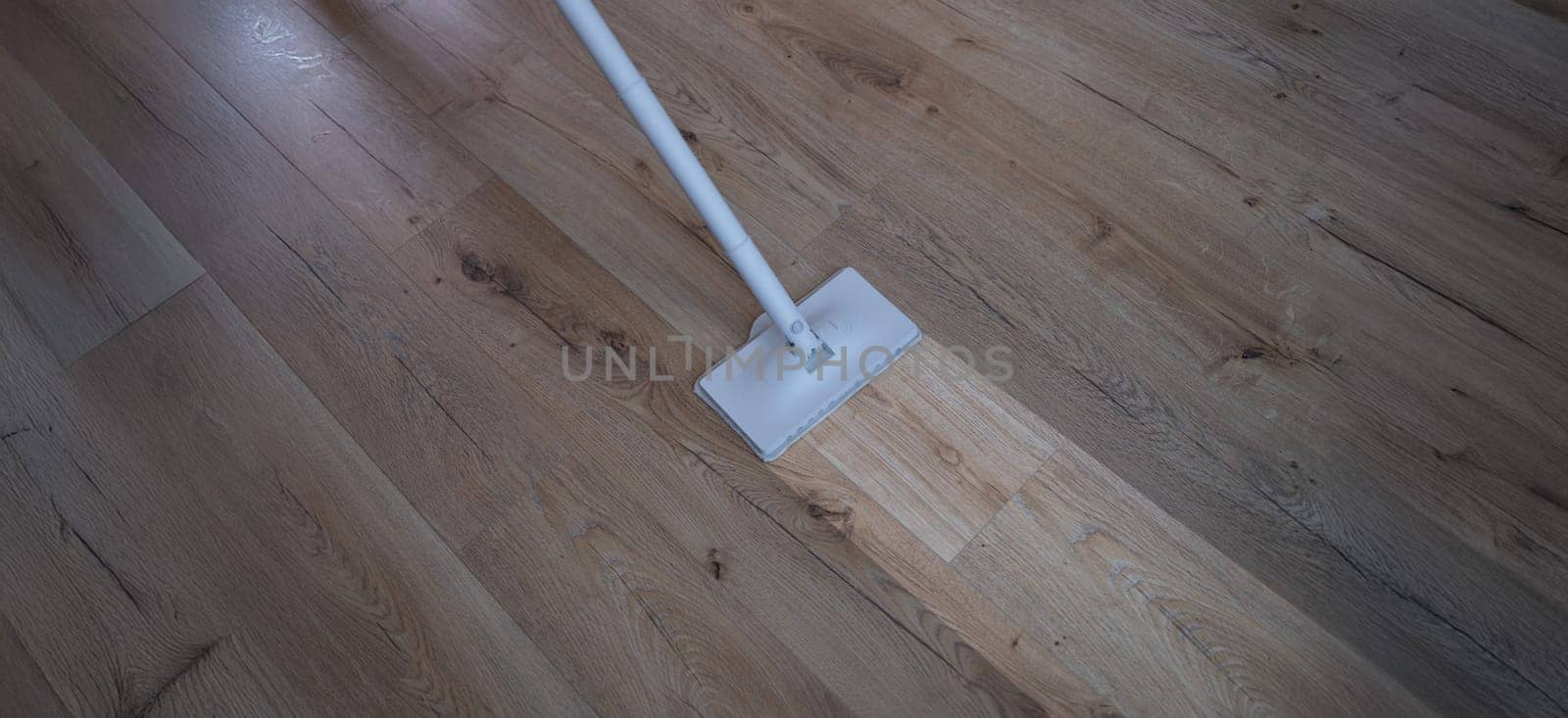 A washing vacuum cleaner washes the laminate, a clean footprint on the floor, close-up. Parquet cleaning equipment