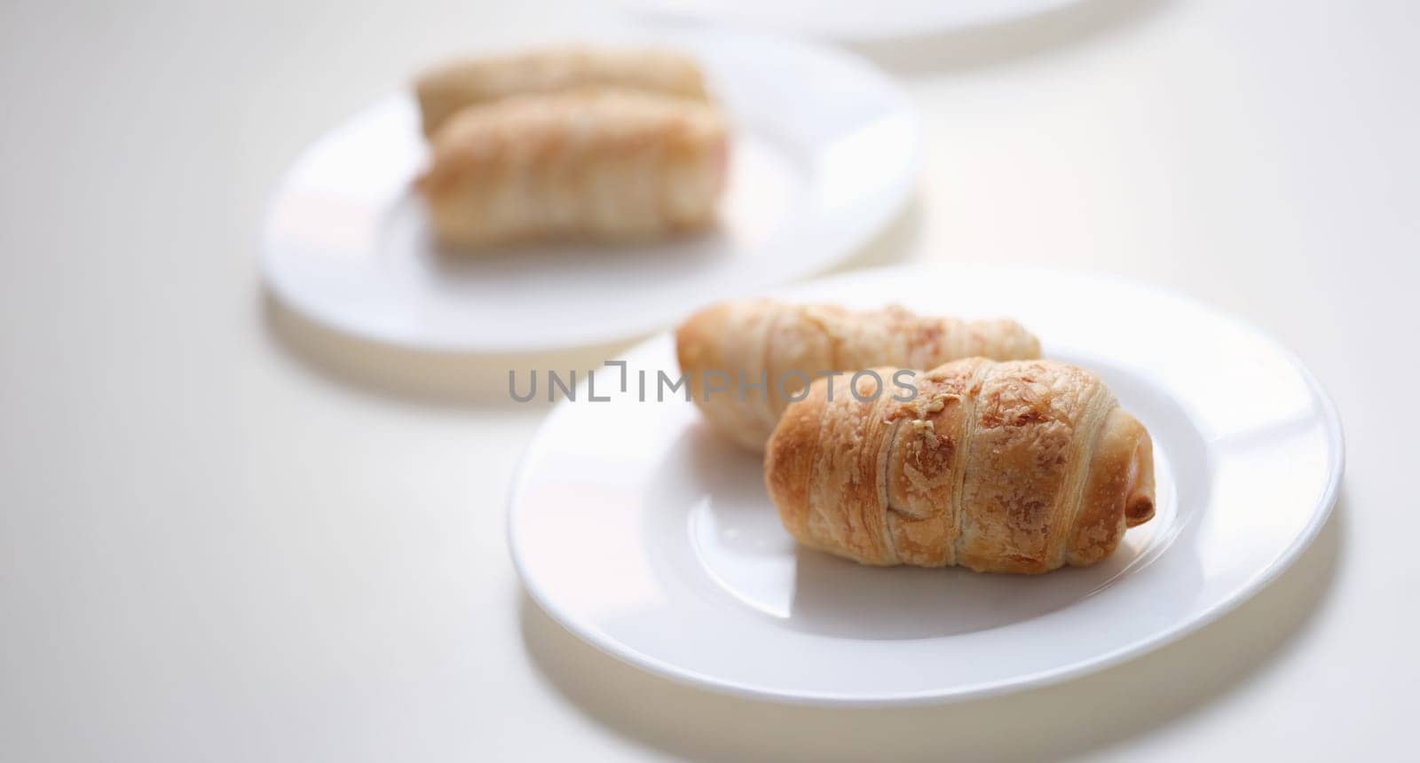 Delicious pigs in a blanket on a white plate, close-up. Mini crescent dogs. Two ingredients. Flaky, savory and perfectly dippable appetizers