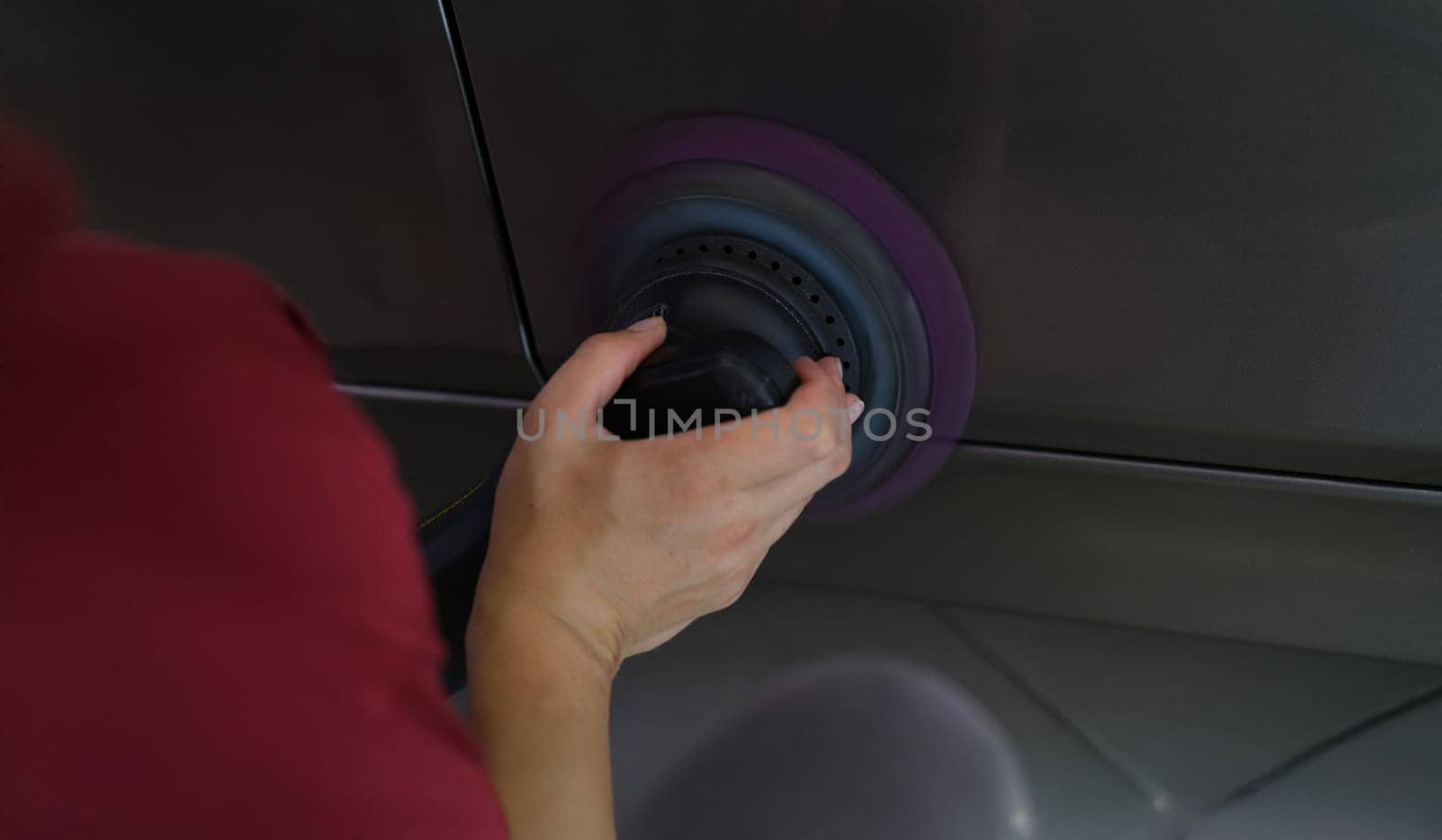 A man polishes a car cover, close-up. Scratch removal tool, abrasive polish, hard polishing disc, detailing