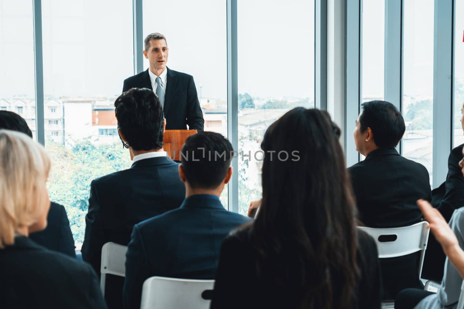 Group of business people meeting in a seminar conference . Audience listening to instructor in employee education training session . Office worker community summit forum with expert speaker . Jivy