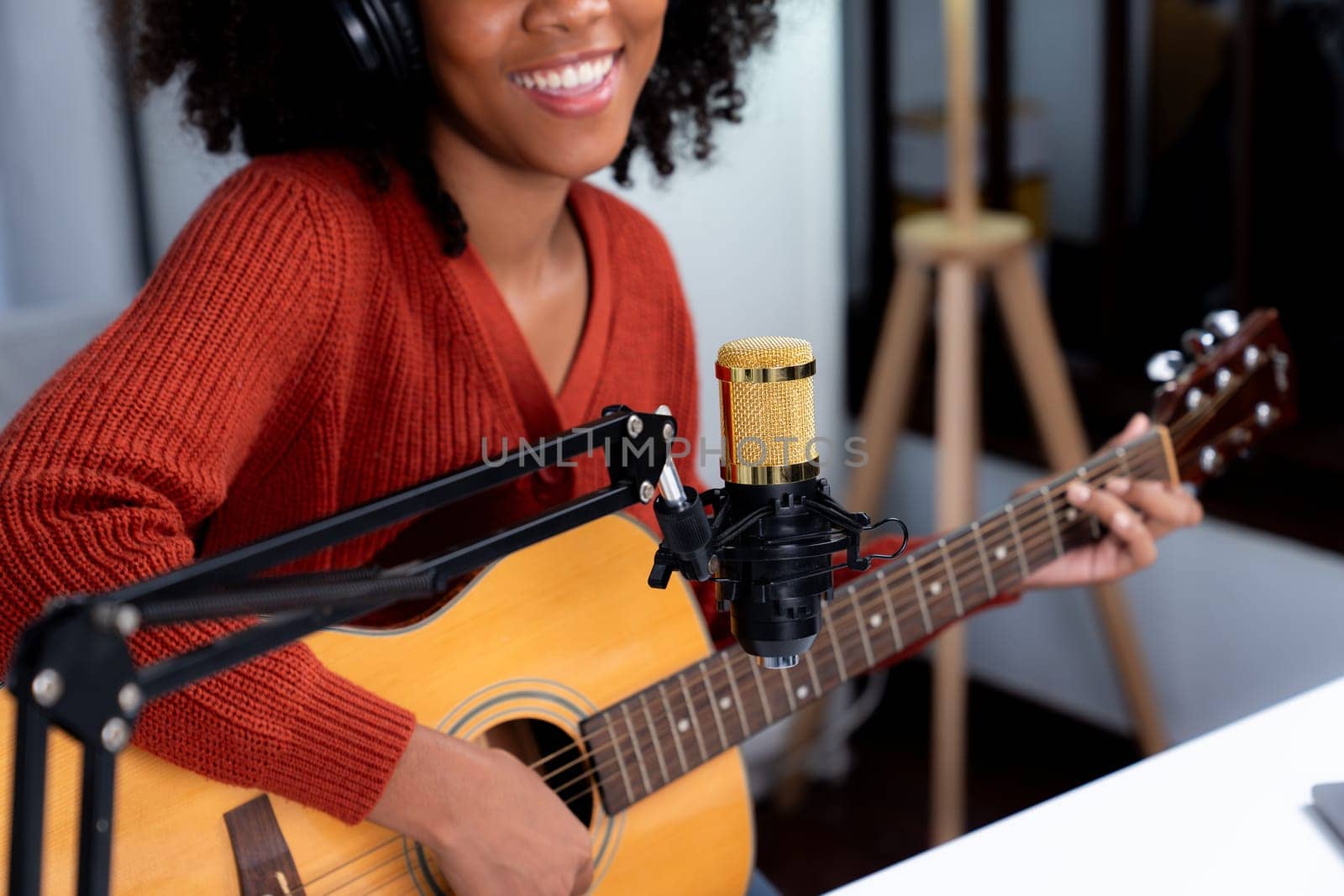 Portrait host channel of beautiful African woman influencer singing with playing guitar on broadcast. Time slot of music blogger on live social media online. Concept of audio creator. Tastemaker.