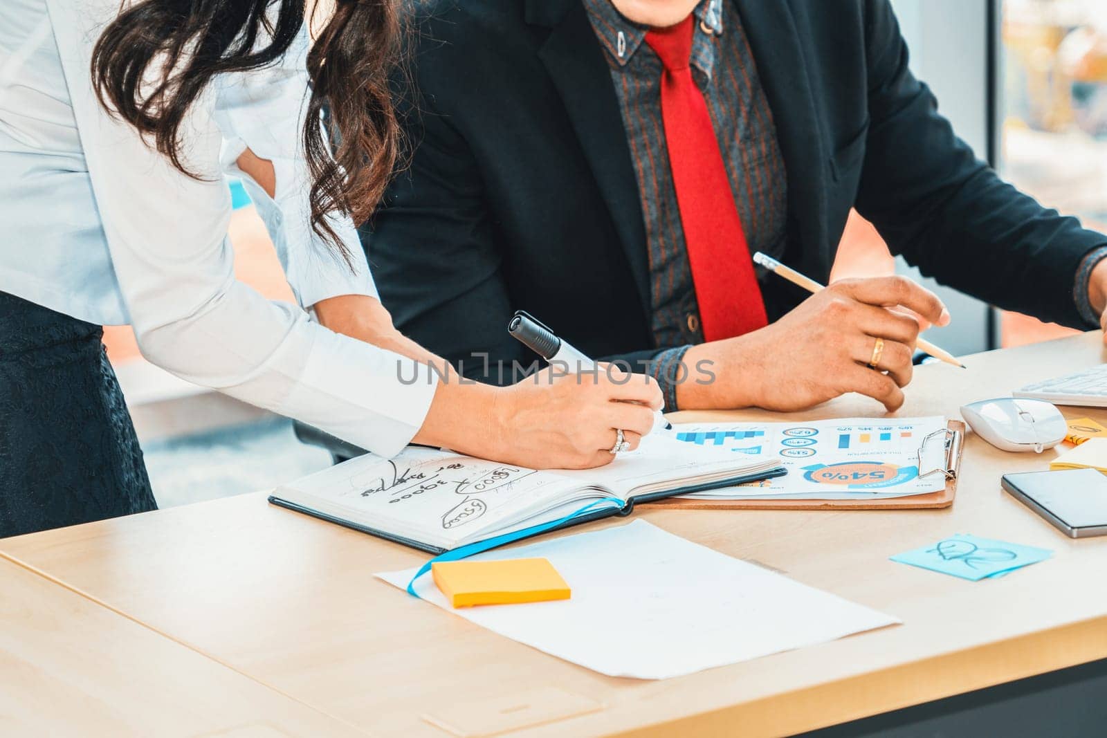 Two business people talk project strategy at office meeting room. Businessman discuss project planning with colleague at modern workplace while having conversation and advice on financial report. Jivy