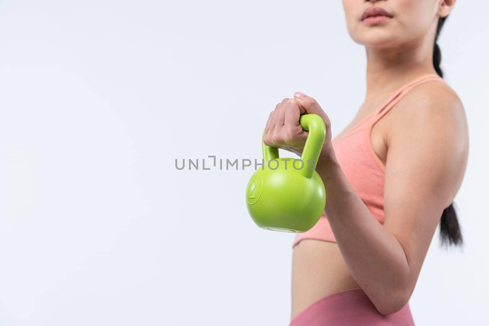 Vigorous energetic woman doing yoga with kettlebell weight exercise. by biancoblue