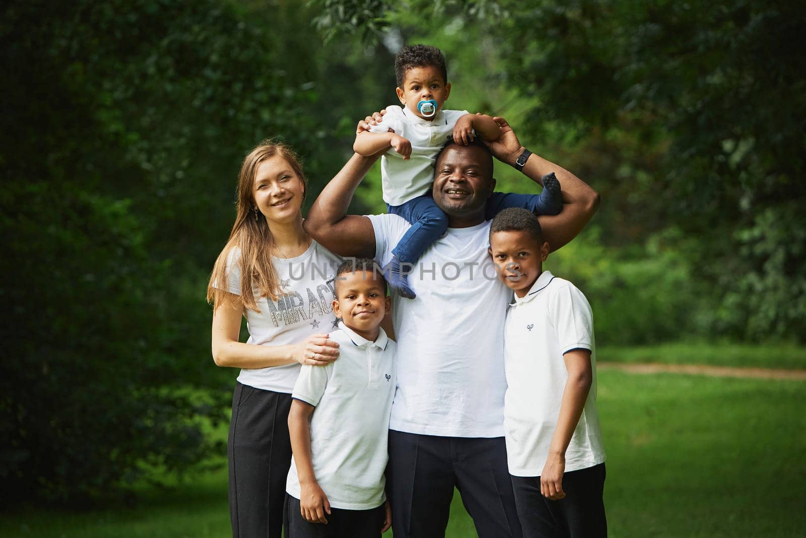 Tilst, Denmark, 12th of August, 2023: Interracial family in the forest by Viktor_Osypenko
