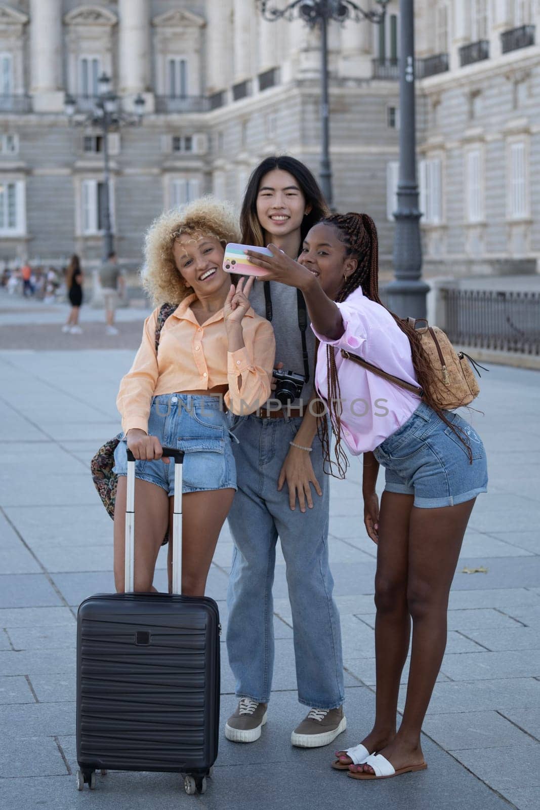 Group of multi ethnic young travellers taking a selfie in Madrid city.