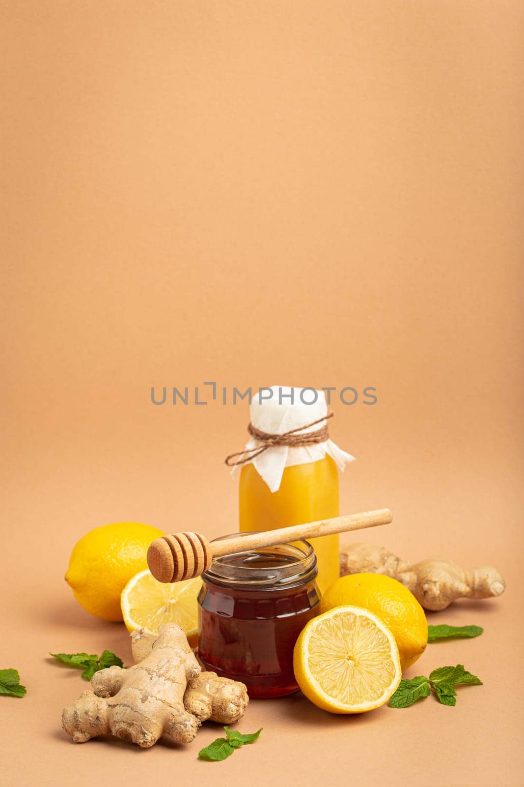 Composition with detox drink, sea buckthorn berries, lemons, mint, ginger, honey in glass jar. Food for immunity stimulation and against flu. Healthy natural remedies to boost immune system.