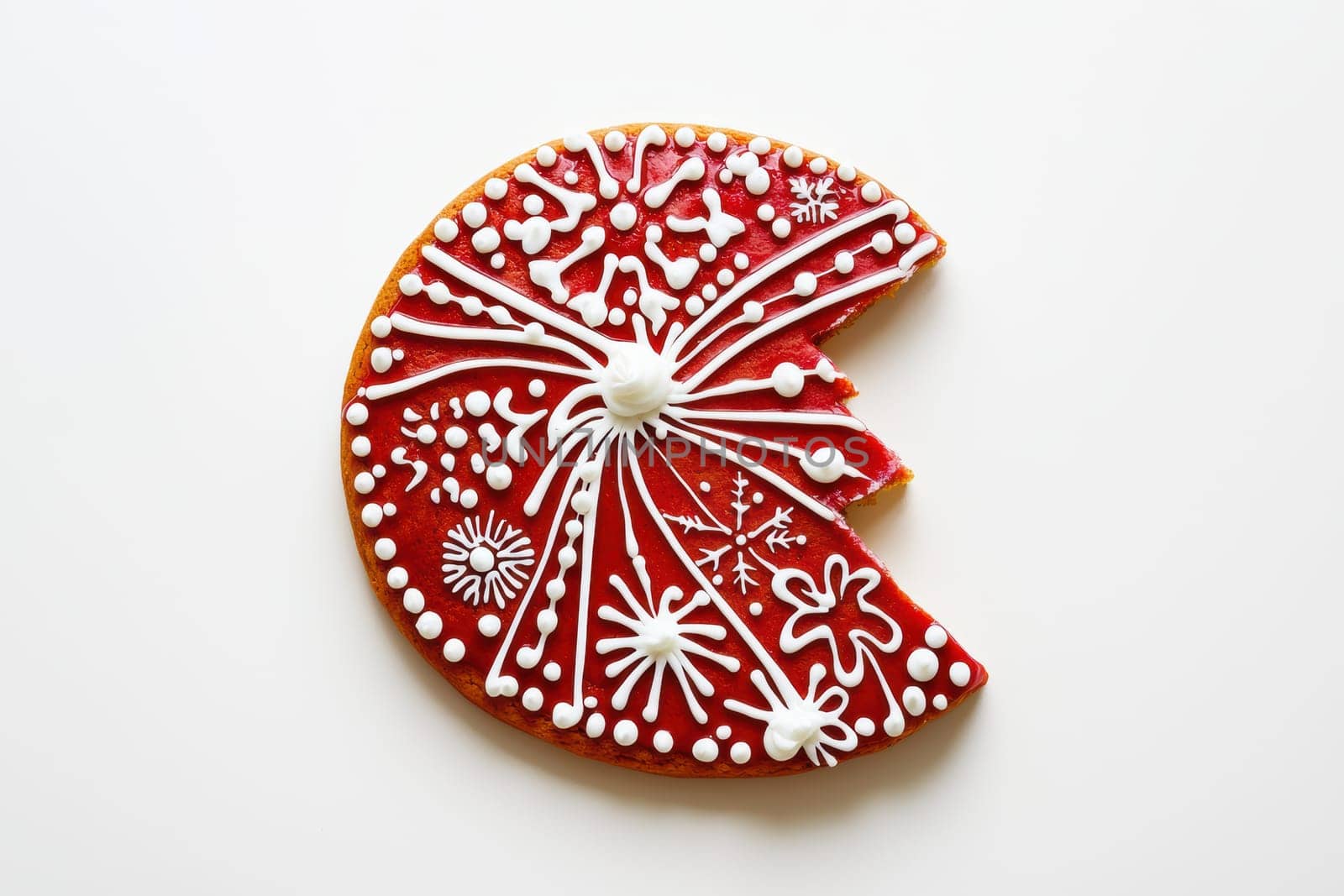 A beautifully decorated red cookie featuring intricate white icing designs, perfect for holiday celebrations.