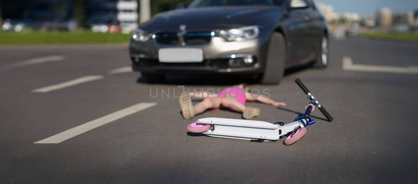 A child on a scooter was hit by a car, close-up, blurry. Trauma, death on the highway, road accident. Child alone in the street