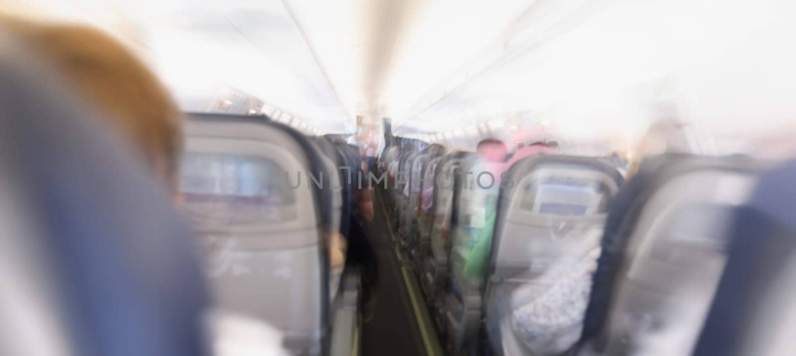 Comfortable passenger cabin of the aircraft, rear view, flashing. Fear of flight, aerophobia. Plane crash, blurred consciousness, blurry