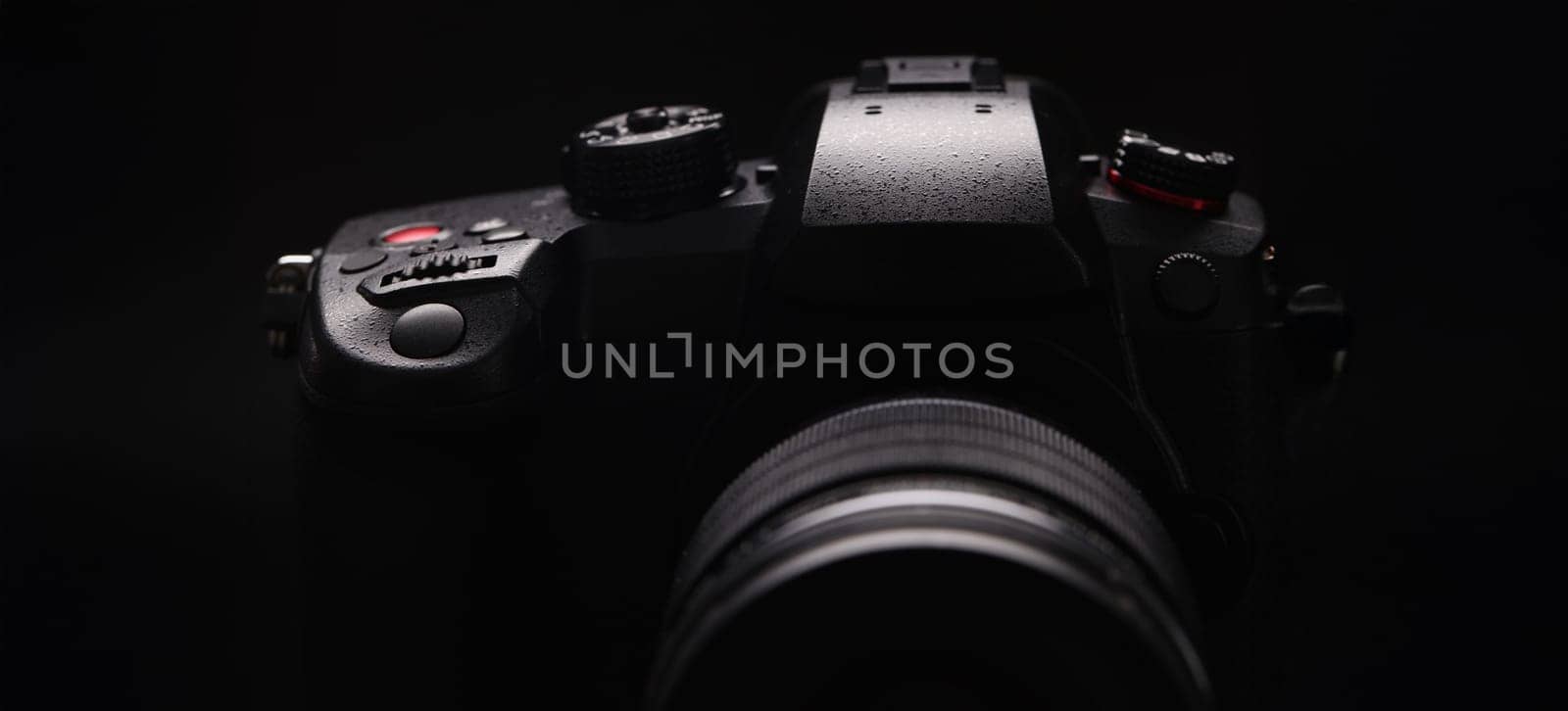 Digital black camera on a black background, close-up. Content creation, professional equipment for a video blogger, streamer