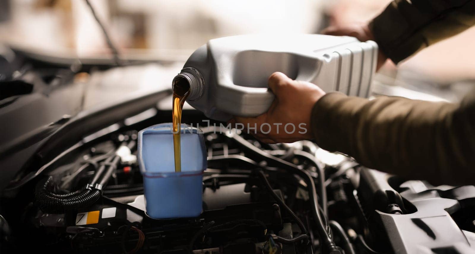 A man pours engine oil into a car, close-up. Service at a service station, vehicle operation. Selection of oil for the automobile