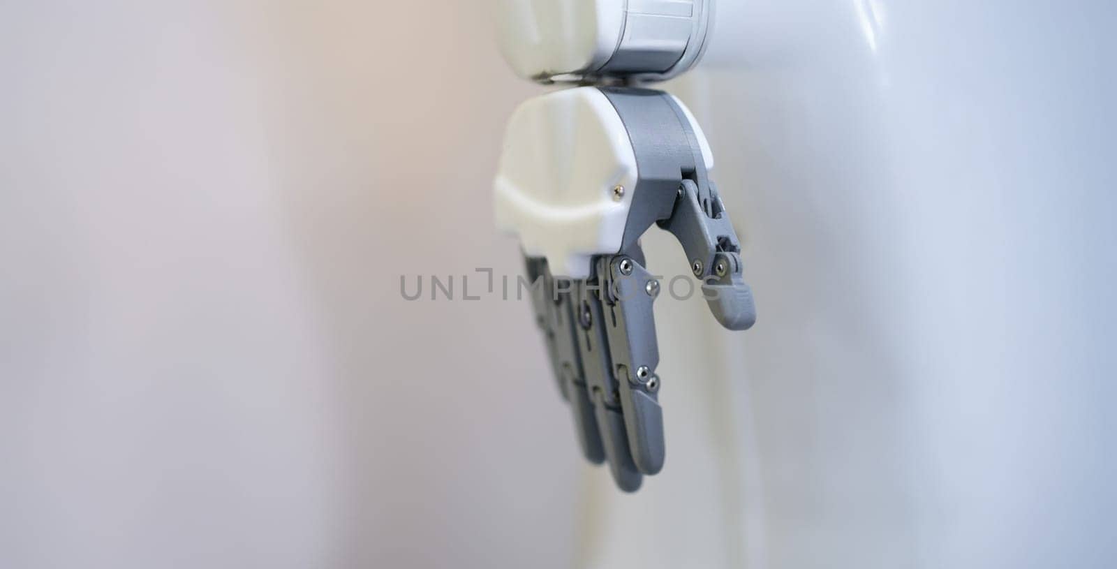Robotic hand with fingers on a white background, close-up. Industrial manipulator, sensor, flexible simulator