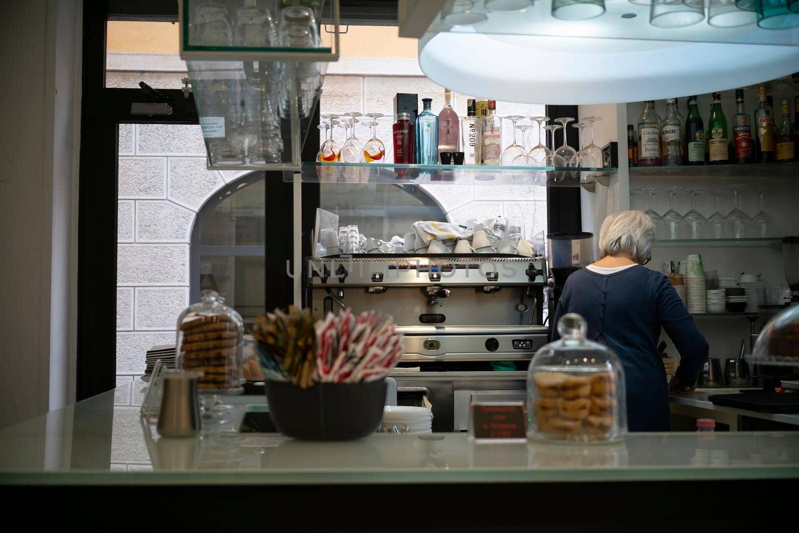 Cremona, Italy - November 20th 2024 Barista working behind the counter of a typical italian cafe in cremona, preparing coffee and serving customers