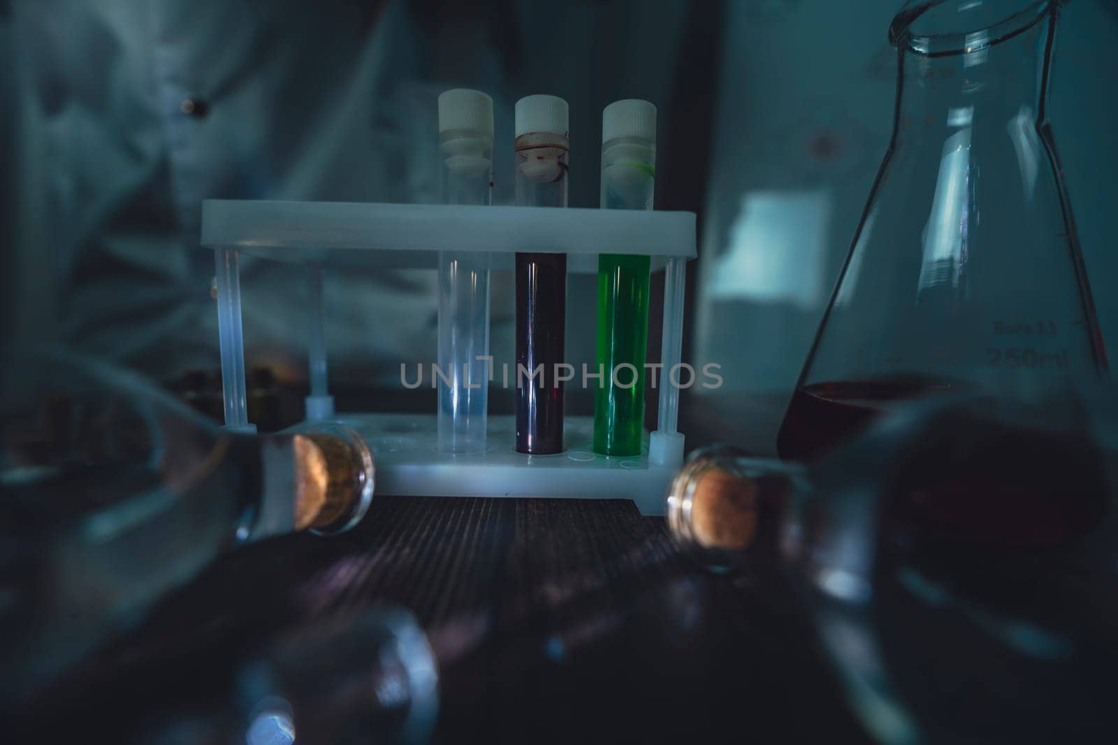 A scientist in a laboratory conducts an experiment with test tubes filled with vibrant liquids, surrounded by various lab equipment. The image showcases professional scientific research