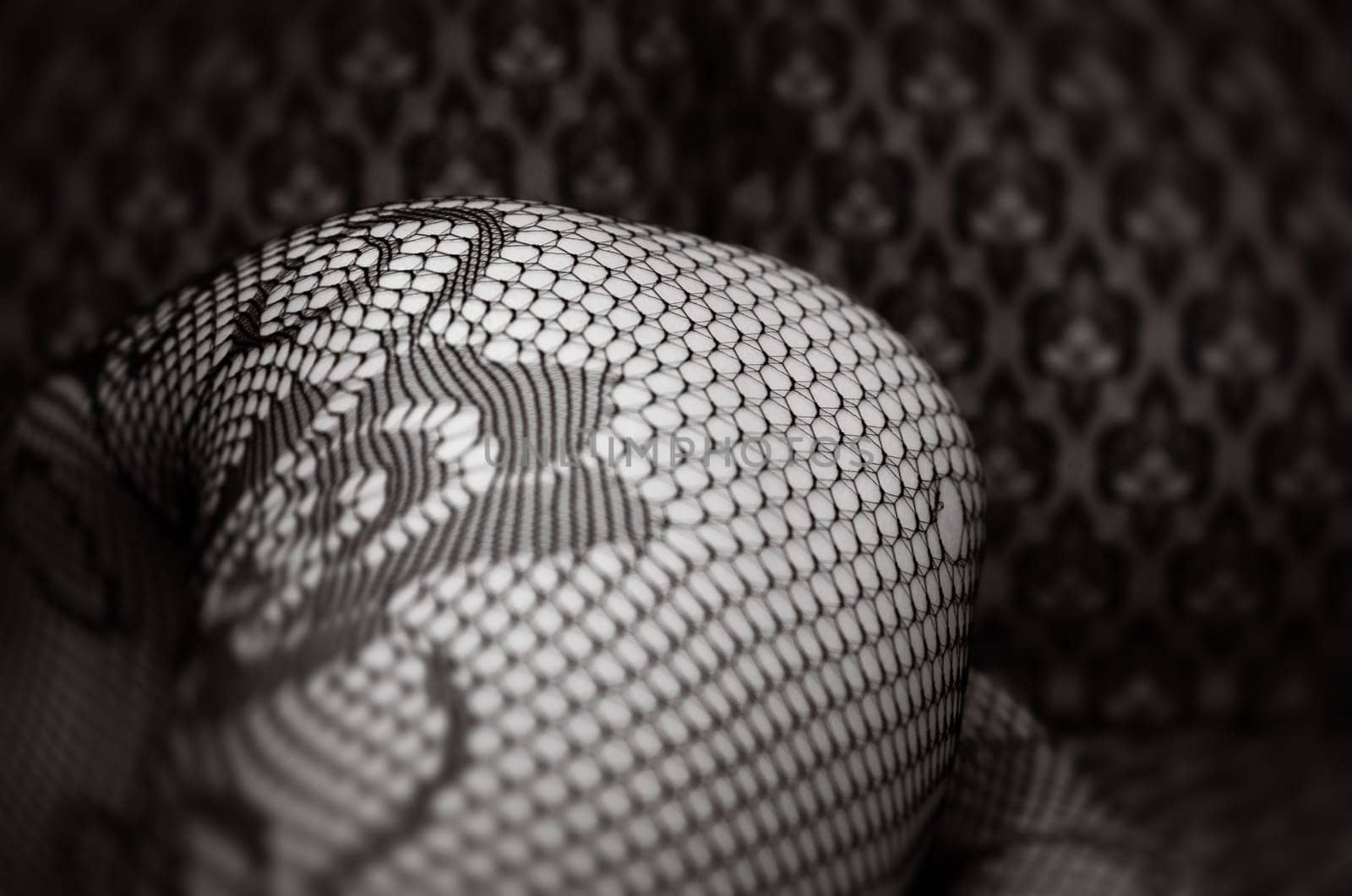 A close-up view showcases the intricate patterns of black lace against a textured surface, creating an elegant visual contrast.