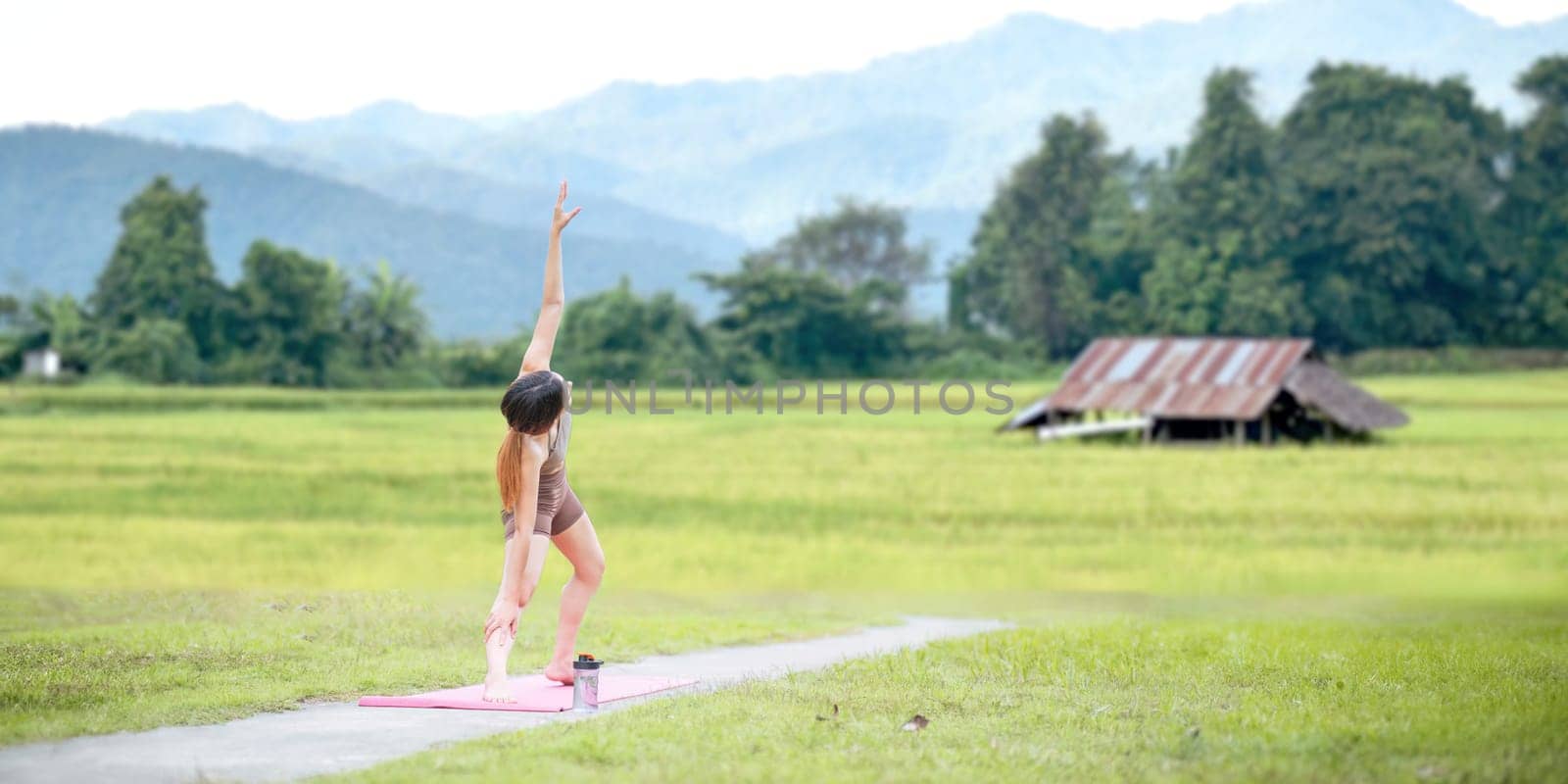 Healthy women doing yoga in the morning In the middle of a rice field . concept healthy and outdoor activity.