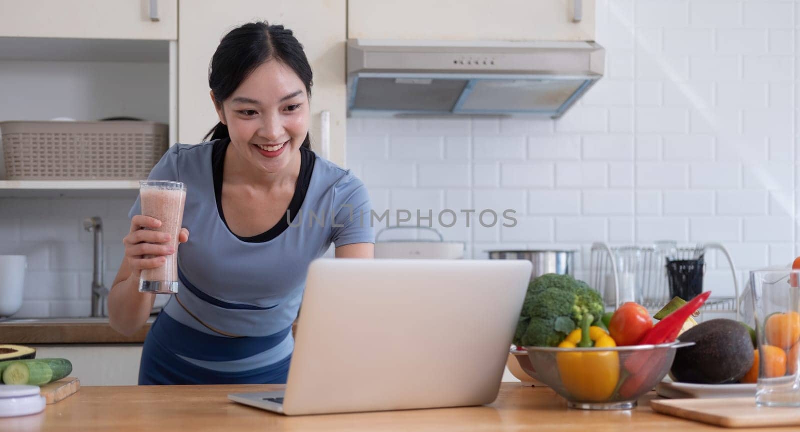 Beauty healthy asian woman making fruit smoothie with blender. woman drinking glass of fruit smoothie in kitchen. Diet concept. healthy drink.