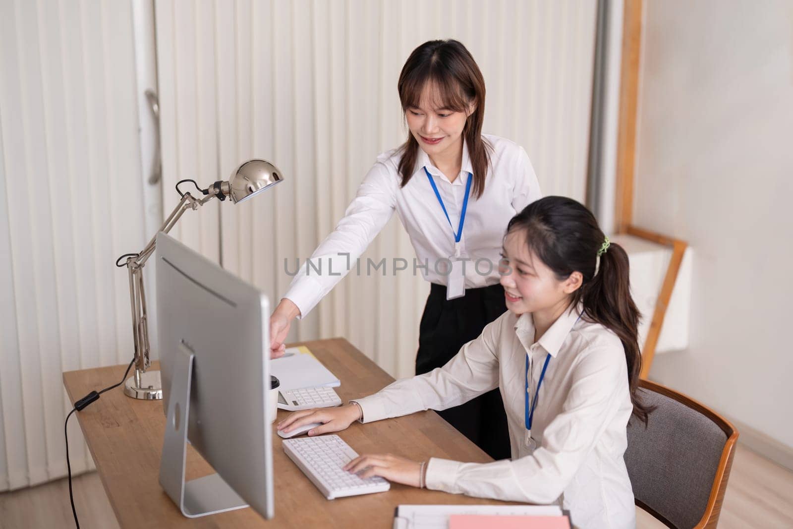 Asian company employee and colleague work together in the office. by talking and giving advice.