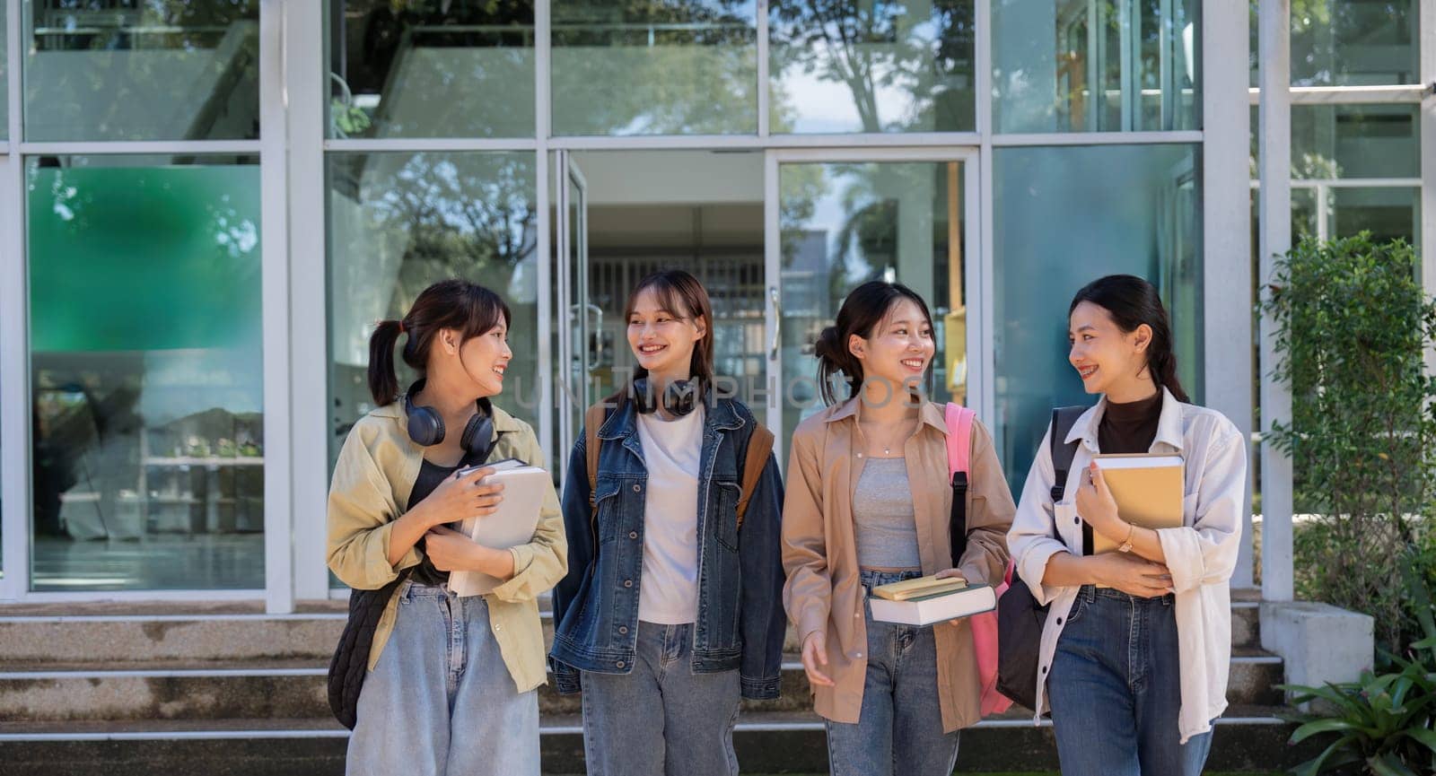 Happy young student chat with each other after class. Guy and girls wear casual clothes to study. Lifestyle concept, sincere emotions.