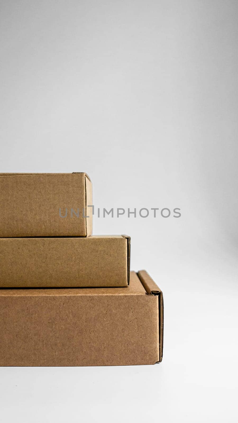 Three neatly stacked brown boxes positioned against a smooth backdrop, ideal for shipping and packaging ideas