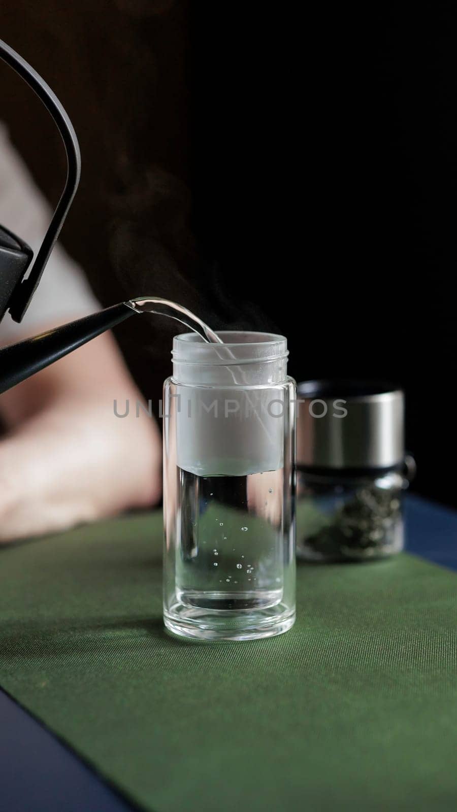 A serene and peaceful moment occurs as hot water gently pours into a clear glass, ideal for tea or coffee enthusiasts