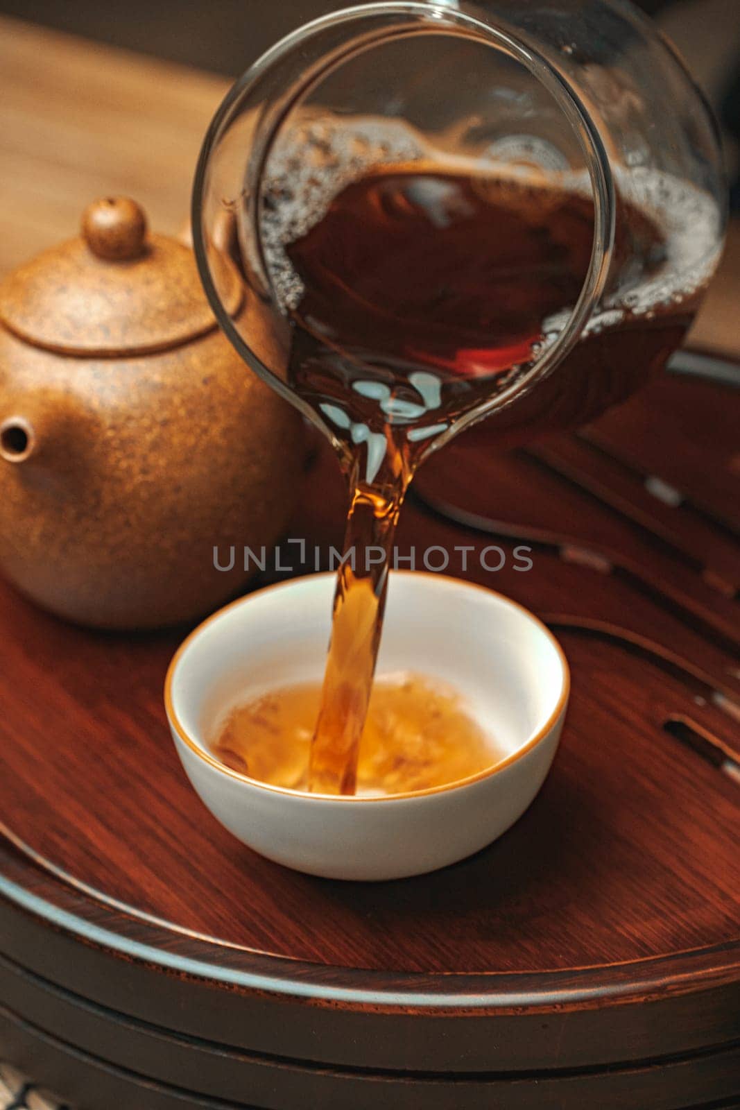 A serene moment as tea pours into a beautifully crafted cup, showcasing its rich color and exquisite teaware
