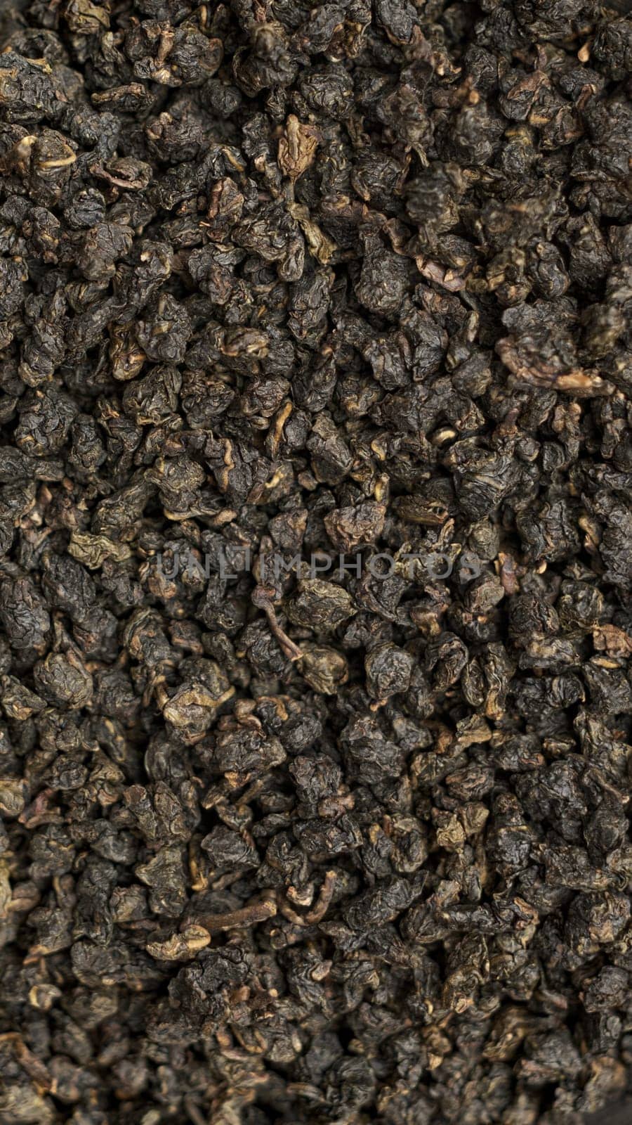 This textured image of dried black tea leaves is perfect for culinary and beverage projects needing visual appeal