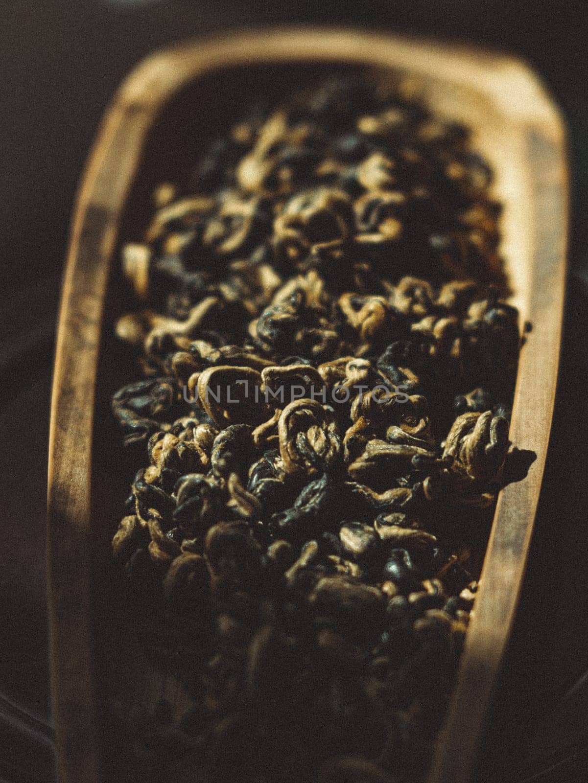 A close view of assorted dried herbs in a rustic wooden scoop, showcasing their natural textures and beauty