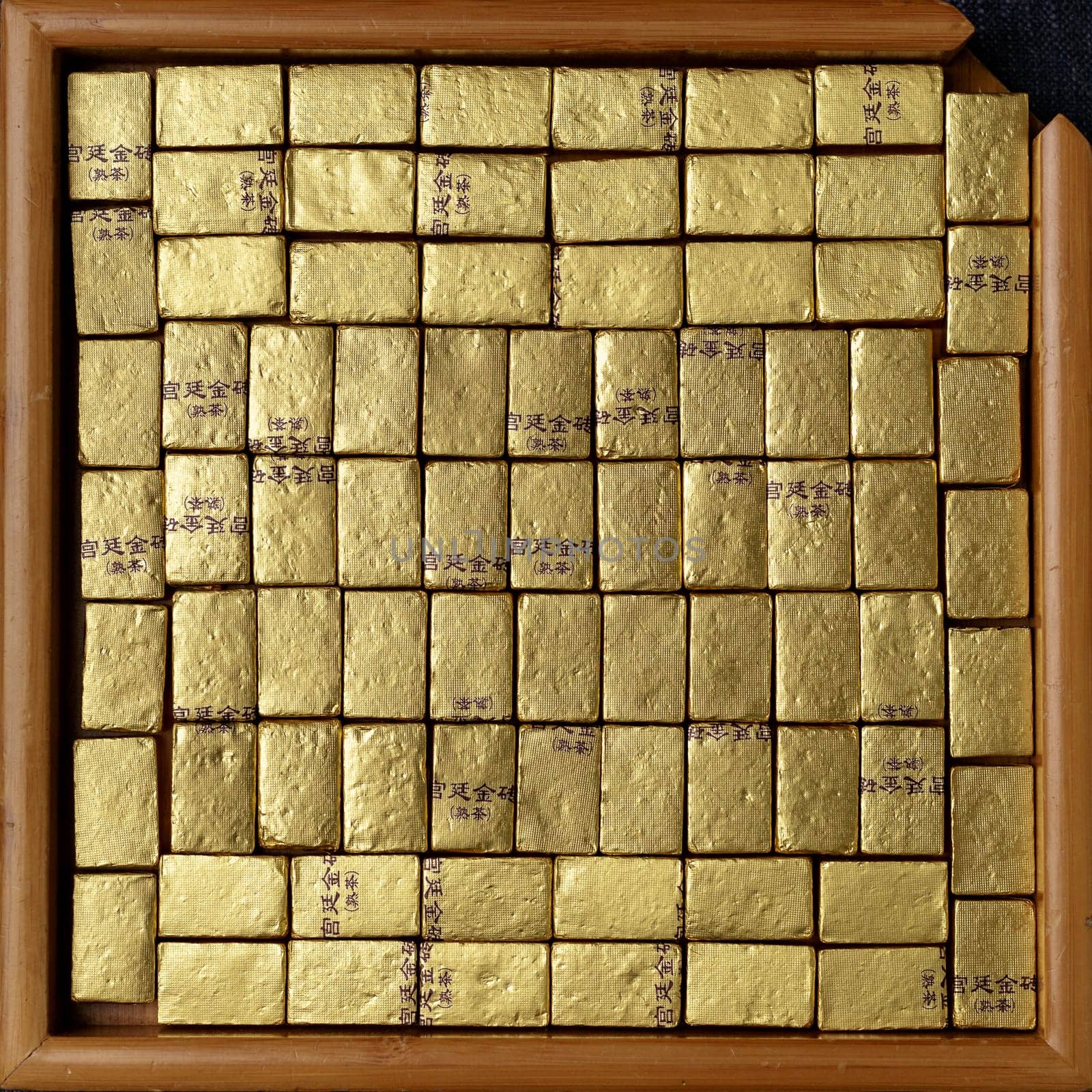An alluring and captivating display of neatly arranged gold bars exquisitely framed within a square wooden frame