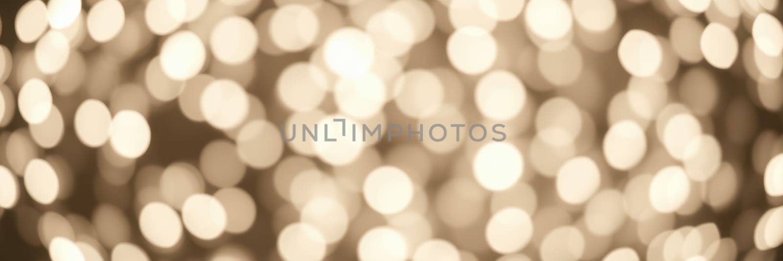 Warm golden lights illuminate a space with a soft bokeh effect, enhancing the cozy ambiance during a festive evening gathering. Guests enjoy the enchanting atmosphere.