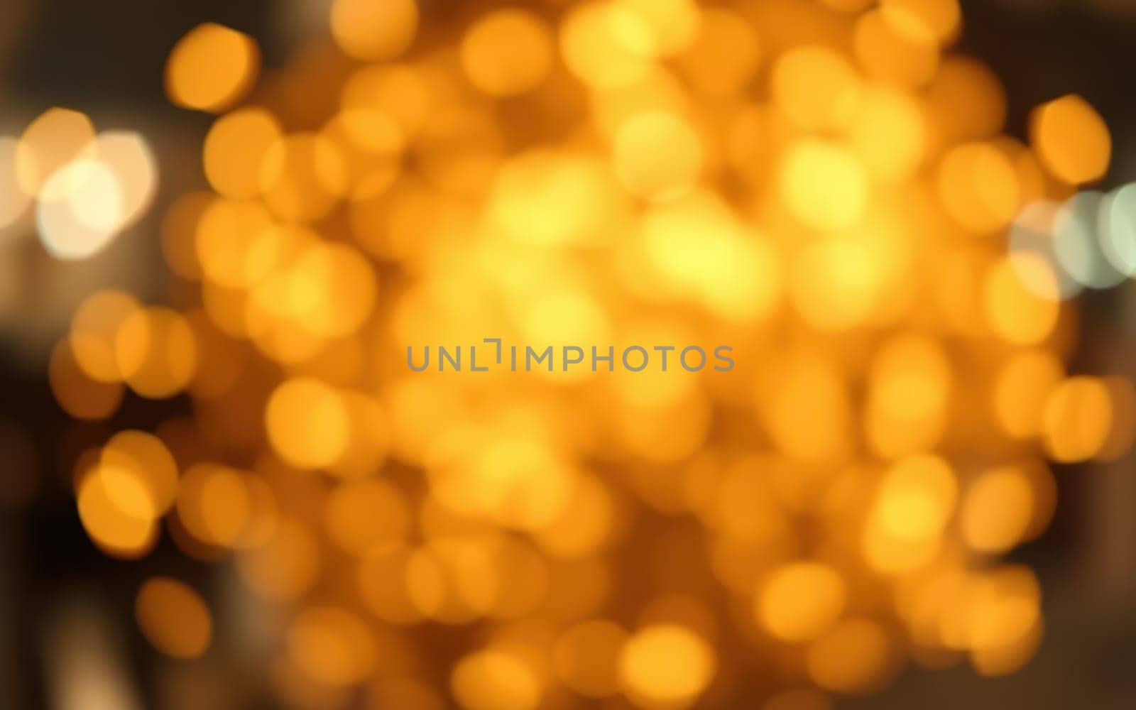 Warm, soft lights illuminate a cozy indoor space filled with a relaxing ambiance. The golden glow enhances the inviting atmosphere of an evening gathering.