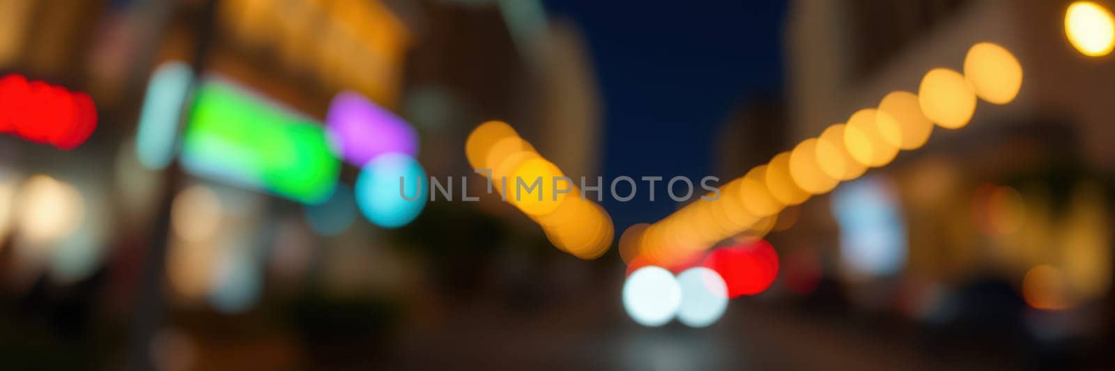 A bustling urban street filled with lights from shops and restaurants as nighttime descends. The vibrant atmosphere attracts pedestrians and vehicles alike, creating a lively urban scene.