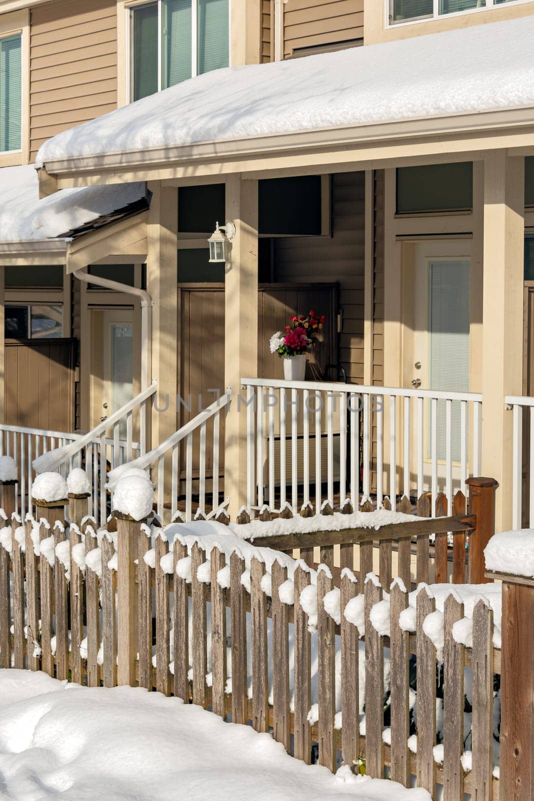 Small front yard, porch and entrance of residential townhouses on winter season in Canada.